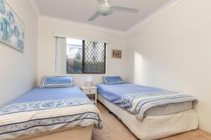 Duas camas num quarto com uma janela em Renas Court 2 em Forster