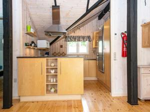 an open kitchen with wooden cabinets and a staircase at 6 person holiday home in Ansager in Ansager