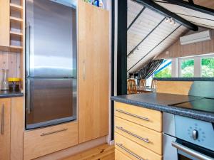 eine Küche mit Holzschränken und einem Kühlschrank aus Edelstahl in der Unterkunft 6 person holiday home in Ansager in Ansager