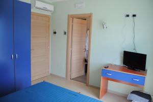 een slaapkamer met een bed en een bureau met een televisie bij B&B Alla Corte Blu in Melfi