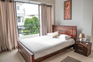 a bedroom with a bed and a large window at Bliss Apartments Colombo in Colombo
