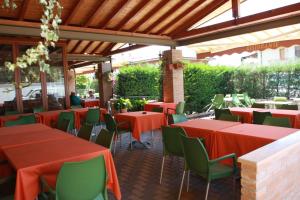 a restaurant with red tables and green chairs at Hotel Venere in Negrar