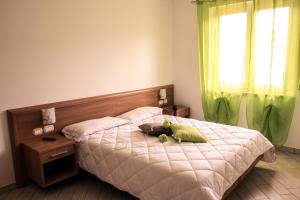 a stuffed animal laying on a bed in a bedroom at Hotel Venere in Negrar