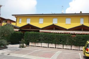 a yellow building with a parking lot in front of it at Hotel Venere in Negrar
