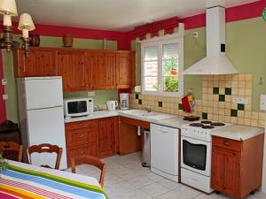 a kitchen with wooden cabinets and white appliances at Gîte Croisilles, 5 pièces, 7 personnes - FR-1-376-63 in Croisilles
