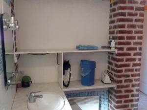 a bathroom with a sink and a brick wall at Gîte Croisilles, 5 pièces, 7 personnes - FR-1-376-63 in Croisilles
