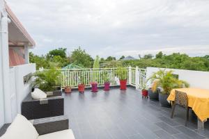 a balcony with a table and potted plants at Le Domharry in Anse-Bertrand