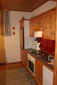 a kitchen with wooden cabinets and a stove top oven at Appartement Schöffmann in Bad Kleinkirchheim