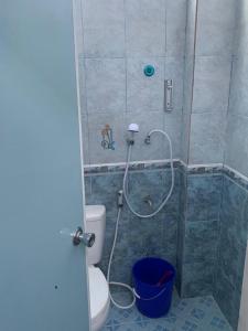 uma casa de banho com um chuveiro, um WC e um balde em Homestay Sultan Ramadhan Aur Kuning Bukittinggi em Bukittinggi