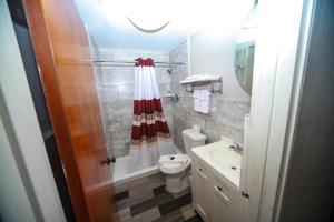 a bathroom with a shower and a toilet and a sink at Relax Inn-Bradford in Bradford