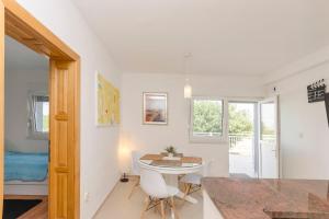 a kitchen and dining room with a table and chairs at Apartments Dujo in Rupe