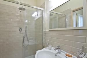 y baño con ducha, lavabo y espejo. en San Marco Apartment, en Florencia