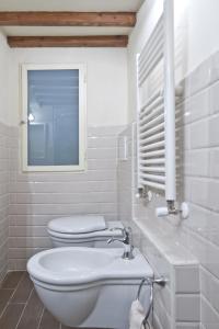 a white bathroom with a toilet and a sink at San Marco Apartment in Florence