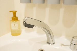 un fregadero con grifo y una botella de jabón en 谷町君･星Hotel･恵美須西, en Osaka 35 fotos más