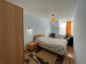 a small bedroom with a bed and a window at Tan Nuru Guest House Гостевой Дом Тан Нуру in Cholpon-Ata