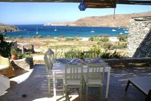 a table and chairs on a patio with a view of the ocean at Serifos Dream Houses near the sea in Ganema