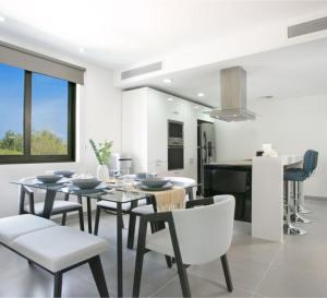 a kitchen and dining room with a table and chairs at Corasol Nick Price By PARR CONDOS in Playa del Carmen