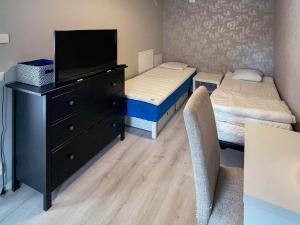 Kleines Zimmer mit 2 Betten und einer Kommode mit einem TV. in der Unterkunft Holiday home ÄNGELHOLM IV in Ängelholm