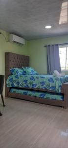 a bedroom with a bed with a blue and white comforter at Apartaestudio Perdomo Shantiers en San Andres Islas in San Andrés