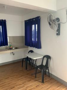 a room with a table and chairs and a fan at Chillax Inn in Tagaytay