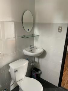 a bathroom with a toilet and a sink and a mirror at Chillax Inn in Tagaytay +69 photos