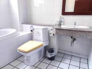 a bathroom with a toilet and a sink at Thong Paeka Hotel in Prasat