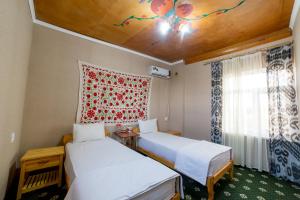 a room with two beds and a window at Islam Khodja in Khiva