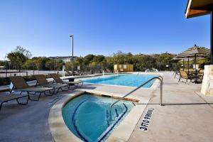 a large swimming pool with chairs at Holiday Inn San Antonio Northwest- SeaWorld Area, an IHG Hotel in San Antonio