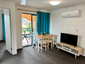 a living room with a table and a television at Aruba Surf Resort in Gold Coast