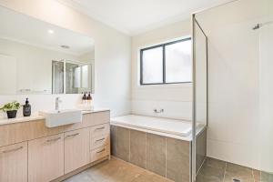 Bilik mandi di KOZYGURU | Greenvale VIC | Roomy Charming | 7 Bed House + Free Parking