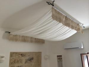 - un rideau suspendu au plafond dans l'établissement Rifugio Degli Svevi, à Bari