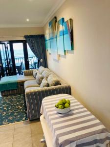 a living room with two couches and a bowl of fruit at 35 on Bondi South Africa in Shelly Beach