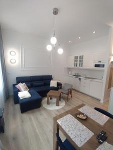 a living room with a blue couch and a table at Apartament FANABERIA Lądek Zdrój in Lądek-Zdrój