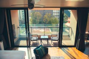 a room with a balcony with a table and chairs at With The Style Fukuoka in Fukuoka
