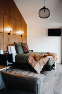 a bedroom with a large bed with a wooden headboard at HighTree Chalets 