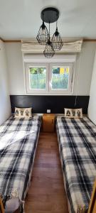 two beds in a room with two windows at Mobil home dans camping in Saillagouse