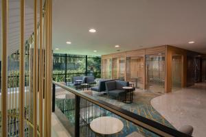 a lobby with chairs and tables on a balcony at Anara Airport Hotel in Tangerang