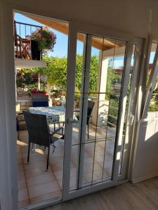 a sliding glass door leading to a patio with a table at Apartments Ivana - free parking and 100m from the beach in Trpanj
