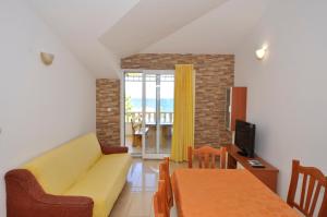 a living room with a yellow couch and a table at Vila Ana Mirela in Slatine