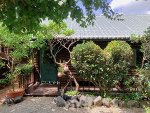 una casa con una puerta verde y algunos árboles en WangWang B&B en Magong