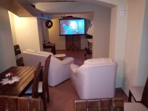 sala de estar con muebles blancos y TV de pantalla plana en Pensjonat Trans, en Szklarska Poręba