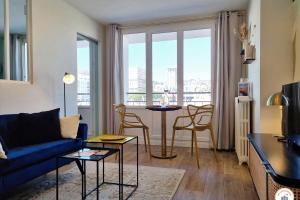 a living room with a couch and a table with chairs at The Four Seasons - Panoramic View - Niemeyer Volcano View in Le Havre