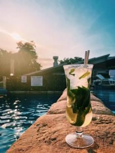 a drink sitting on a ledge next to the water at MOM Darwin in Darwin