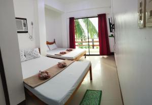 a room with two beds and a window at Joyful Guest House in El Nido