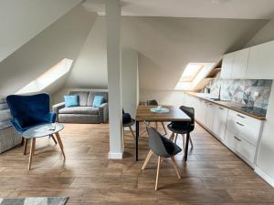 a kitchen and living room with a table and chairs at Villa Continental in Pobierowo