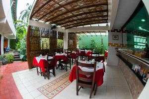 a restaurant with tables and chairs with red table cloth at Pousada Solar D Alcina in Paraty