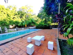 un banco blanco junto a una piscina en Hotel La Aparesida, en Areguá