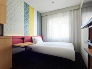 a bedroom with a white bed and a window at Mitsui Garden Hotel Kyoto Shijo in Kyoto