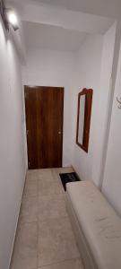 a small room with a bed and a wooden door at Departamento San Martín in Paraná