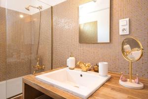 een badkamer met een wastafel, een douche en een spiegel bij Un balcon sur Notre Dame in Marseille